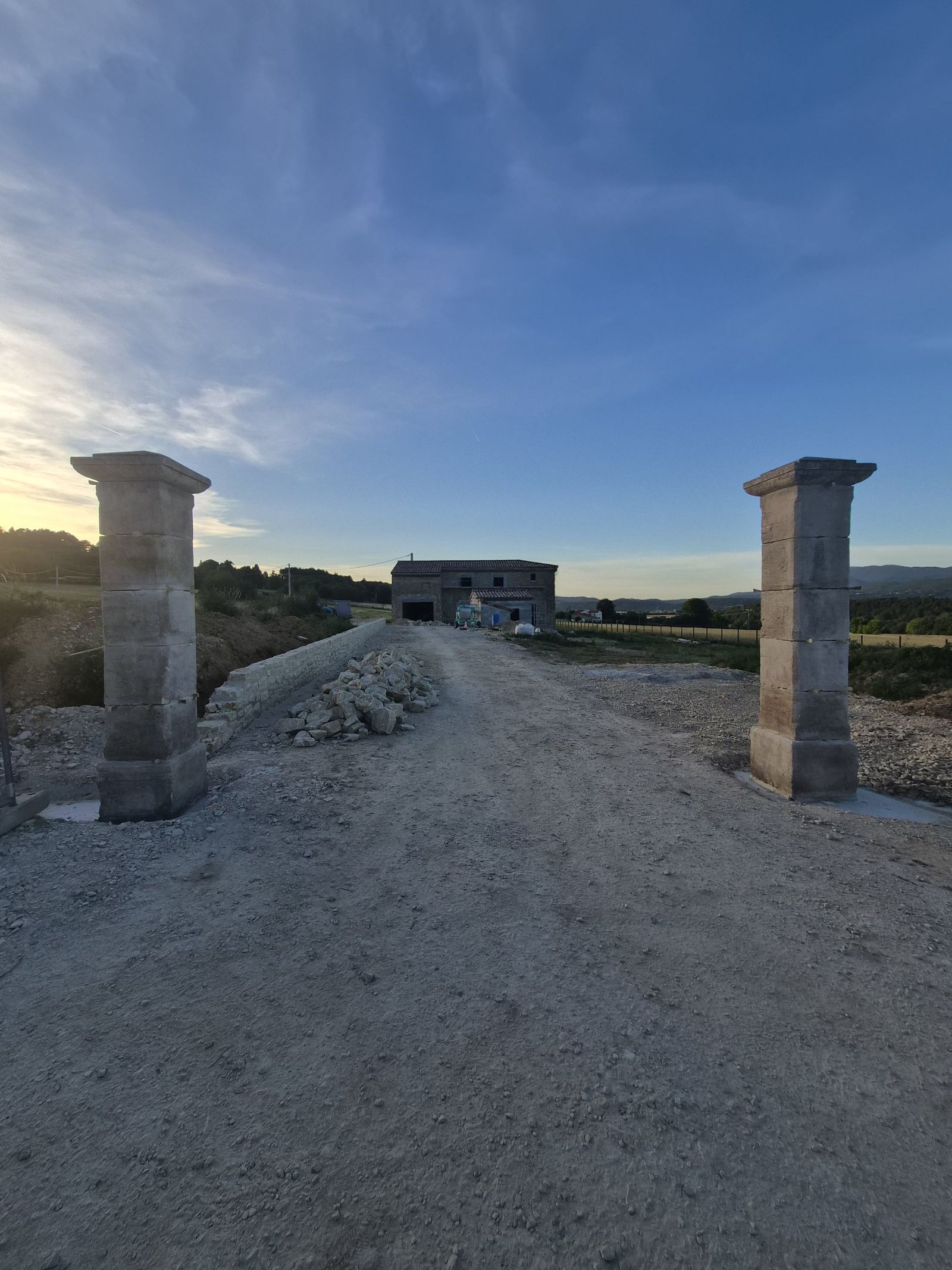 Le portail de pierre et le mas Les Trois Vues au coucher du soleil, Divajeu